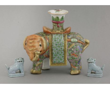 A Canton elephant Candlestick,late 19th century, the orange-headed beast with purple, dotted skin bearing a saddlecloth and f