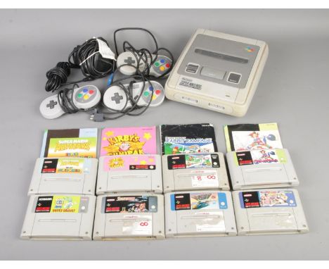A Super Nintendo Entertainment System (SNES) games console, PAL Version, along with eight unboxed games to include Super Mari