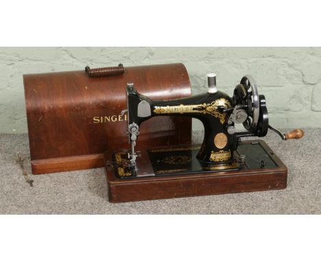 A vintage c1934 wooden cased Singer 28K sewing machine, with keys.