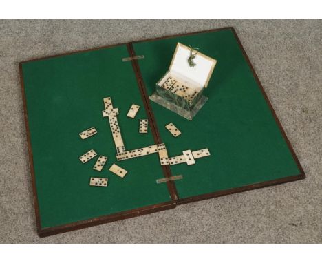 A set of bone dominoes along with a folding table top games table.