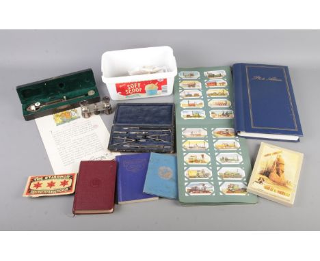 A quantity of assorted collectables to include pair of Rathenow opera glasses, cigarette cards, books of postcards, compass s