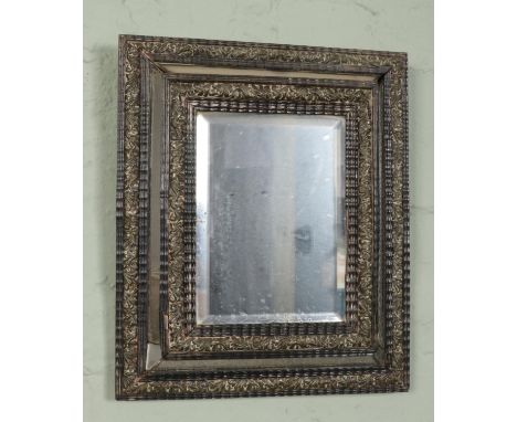 An antique brass mounted cushion mirror. 39cm x 33cm.  Crack to glass.