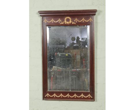 A mahogany Regency style wall mirror, with gilt swag and bow detailing. Height: 90cm, Width: 59cm.