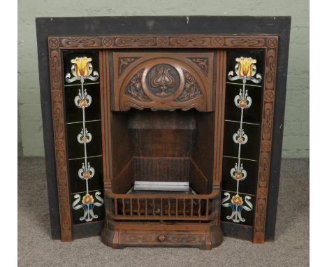A cast iron art nouveau style fireplace with decorative floral tile surround along with grate and other accessories. Height: 