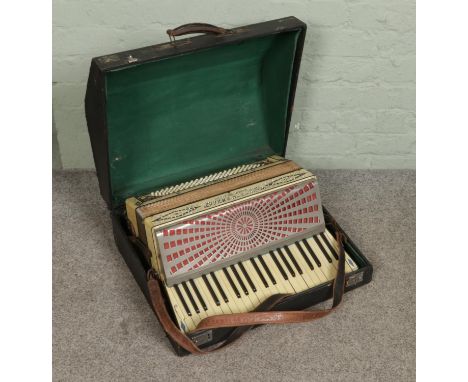 A cased Settimio Soprani Three accordion with faux mother of pearl decoration.