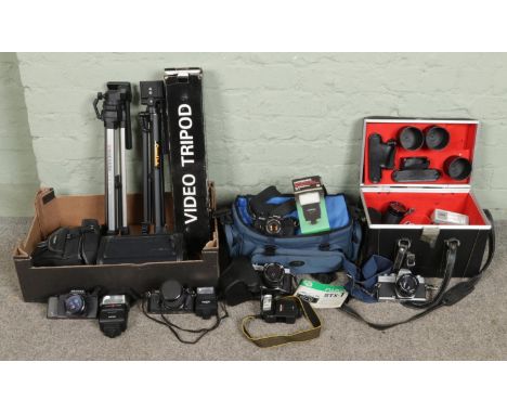 A collection of assorted vintage cameras and tripods, including Minolta SRT100X, Fuji STX-2, Pentax A3, Chinon CE-4, Fujica S