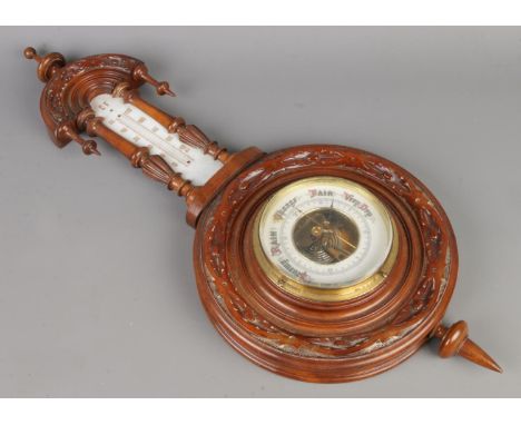 An antique carved walnut wall barometer, size L59 x W24cm.  Missing temperature thermometer.