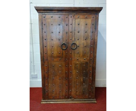 A very good and attractive rustic style wardrobe having studded doors with ring-pull iron handles, opening to reveal planked-