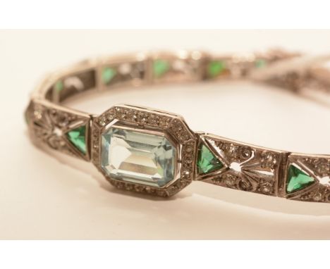 An early 20th Century paste and white metal bracelet, in Art Deco style, set with light blue principal stone surrounded by wh