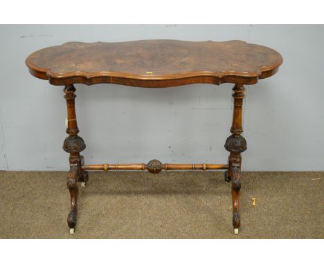 A Victorian burr walnut and inlaid centre table, the shaped oval top decorated with leaf design, raised on turned and carved 