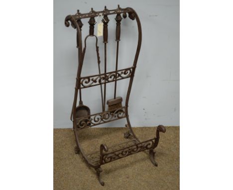 A 20th Century cast iron log holder, with s scroll supports and pierced foliate scroll horizontals, with four hangers for fir