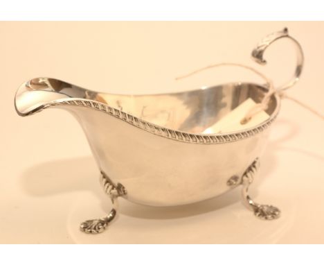 A silver sauce boat, by Charles S Green &amp; Co, Birmingham 1920, with gadrooned rim, scrolling handle and shell pattern fee