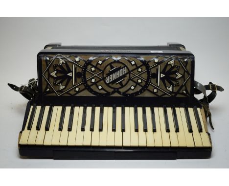 A Hohner Organola II piano accordion, with black plastic caseing.