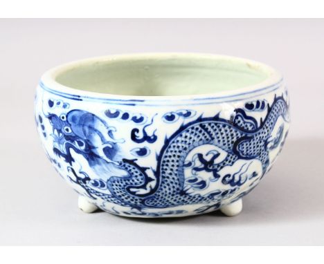 A CHINESE BLUE &amp; WHITE PORCELAIN DRAGON BRUSH POT - with tripod feet, depicting dragons chasing the pearl, AF - restored 