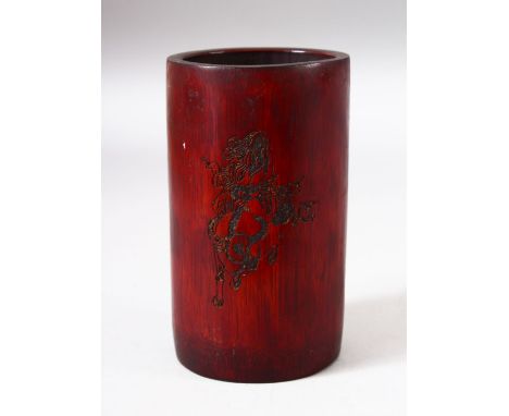 A CHINESE BAMBOO BRUSH POT, with incised decoration depicting a sage / deity and calligraphy, 14cm high.