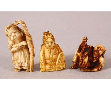 THREE JAPANESE MEIJI PERIOD CARVED IVORY NETSUKE - one depicting a lucky god holding his staff, 5cm together with another two