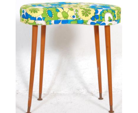 A retro vintage kidney shaped stool upholstered in blue yellow and white fabric raised on tapering legs.&nbsp;