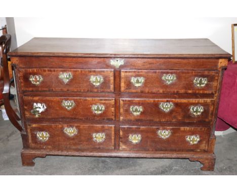 A Georgian oak and mahogany cross banded dresser base, fitted six drawers with brass drop handles, butterfly escutcheons and 