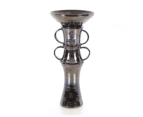 A dark lustre glazed Studio pottery candlestick, with ring handles and raised decoration, 33cm high&nbsp;
