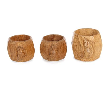 Workshop of Robert "Mouseman" Thompson of Kilburn, a pair of oak napkin rings with trademark carved mouse, and a larger examp