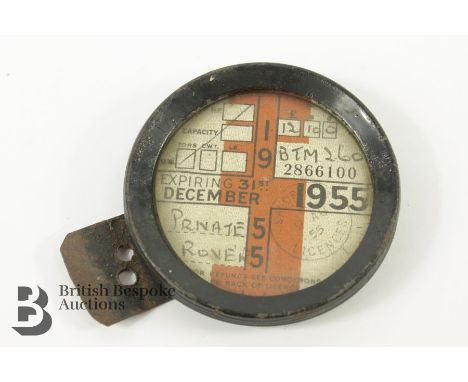 A vintage tax disc from 1955 for a private Rover, reg BTM 260 in a tax disc holder.