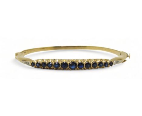 A Sapphire and diamond bangle with 9ct gold hallmarks for London 1987. Inner diameter 5.7cm x 5.2cm, weight 13gms Condition R