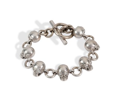 A handmade Bill Wall-style 18ct white gold and diamond skull bracelet. The bracelet having seven skull charms set with diamon