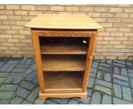 Ercol - A blonde wood Ercol media / hifi storage unit with glazed door and two glass internal shelves 82cm (h) x 57cm (w) x 5