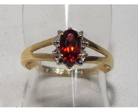 A lady's 9 carat gold hallmarked garnet and diamond ring, size M, boxed, approximate weight 1.6 grams