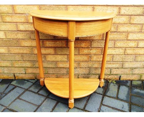 Ercol - A half moon blonde wood Ercol occasional table on three legs 70 cm (h) 67(w) x 33cm (d) 