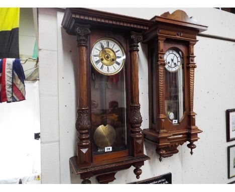 A Vienna style wall clock in a walnut case with carved and turned decoration, glazed opening door displays the white enamel d