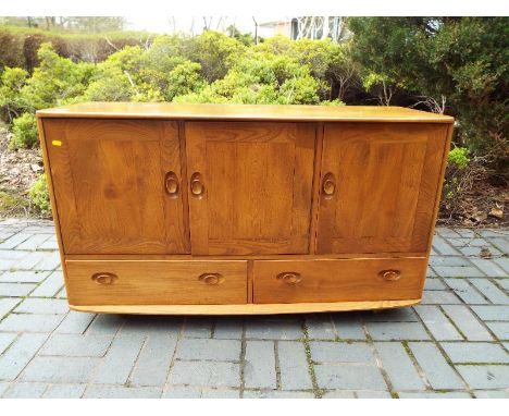 Ercol - An Ercol blonde wood solid elm Windsor sideboard / buffet unit with three cupboards and two drawers with wooden handl