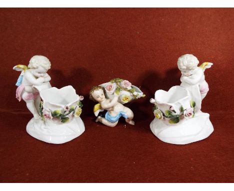 A pair of Sitzendorf posy vases in the form of cherubs 13 cm (h) and a further posy vase in the form of a cherub marked BKM (