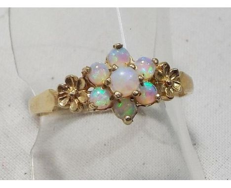 A lady's 9 carat gold hallmarked opal daisy cluster ring, size N and a half, boxed, approximate weight 1.5 grams