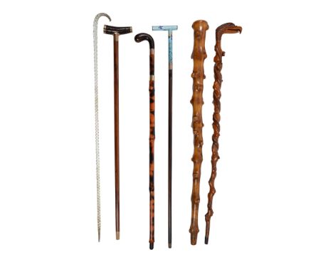 Ω A small quantity of assorted walking sticks, comprising a late Victorian twisted glass frigger stick, 93cm long; a Continen