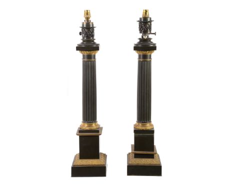  A pair of patinated and gilt metal columnar table lamps in Neoclassical taste,   20th century, with electrical fitments abov