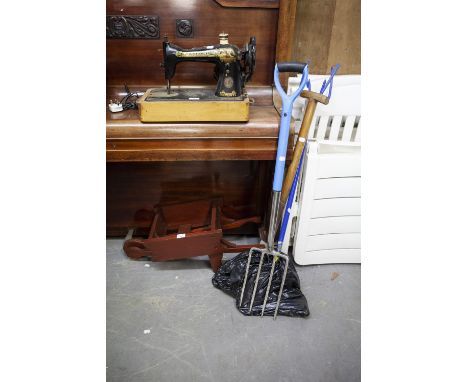 A SMALL WOODEN WHEELBARROW AND GARDEN TOOLS (4) 