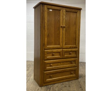 A Canadian oak tall boy, a pair of panelled doors enclosing a shelf and a drawer, above two short and two long drawers to bas
