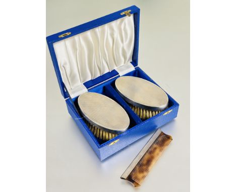 A fitted case containing a pair of Birmingham silver backed oval hair brushes with natural bristles H x 5cm L x 15.5cm W 7cm 