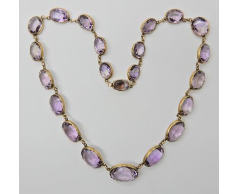 A YELLOW METAL MOUNTED GRADUATED AMETHYST NECKLACE the facet cut amethysts are in cut back spectacle mounts and range in size