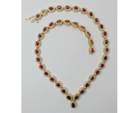 A 14K DIAMOND AND RUBY NECKLACE set with pear shaped rubies of approx dimensions 5.5mm x 3.6mm x 2.8mm (one ruby missing) and
