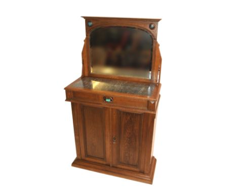 A CONTINENTAL OAK CABINET the mirror back set with ceramic and brass medallions above a marble top and single drawer above a 