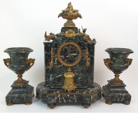 A 19TH CENTURY FRENCH GREEN MARBLE AND ORMOLU MOUNTED CLOCK with applied metal Roman numerals with a pair of matching urn gar