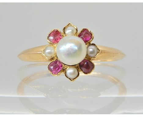 A PEARL AND RED GEM FLOWER RING central pearl is button shaped and approx 4.7mm, with four cushion cut red gems set to a yell
