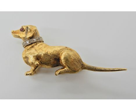 AN 18CT GOLD AND DIAMOND DACHSHUND DOG BROOCH with a ruby set eye. Hallmarked London 1967. Dimensions 4.7cm x 2cm, weight 9.1