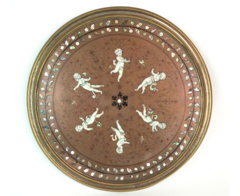 A CIRCULAR GILT-METAL AND MOTHER OF PEARL INLAID WALL PLAQUE depicting five cherubs, 41cm wide Gilbert Telfer Collection, Edi