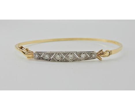 A YELLOW METAL DIAMOND SET BANGLE with unusual hook and safety clasp closure. The diamonds are set to a pieced and millgraine