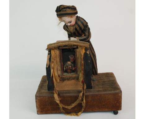 A LATE 19TH CENTURY FRENCH MUSICAL AUTOMATON depicting a puppet show, the standing doll with bisque head possibly Jumeau with