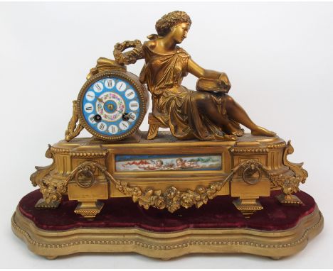 A SERVES STYLE AND ORMOLU GILT MANTLE CLOCK modelled as a seated classical maiden with japy freres movement upon gilded wood 
