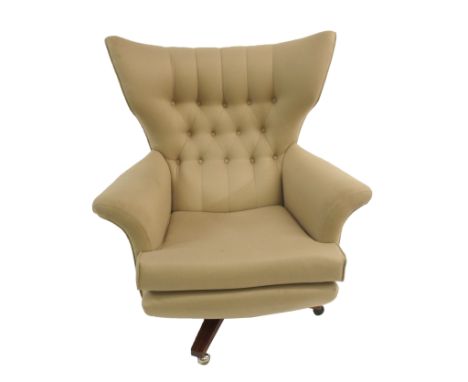 A G-PLAN BUTTON BACK SWIVEL ARMCHAIRwith rosewood base, 97cm highThis item is offered for sale as a work of art, it may not c